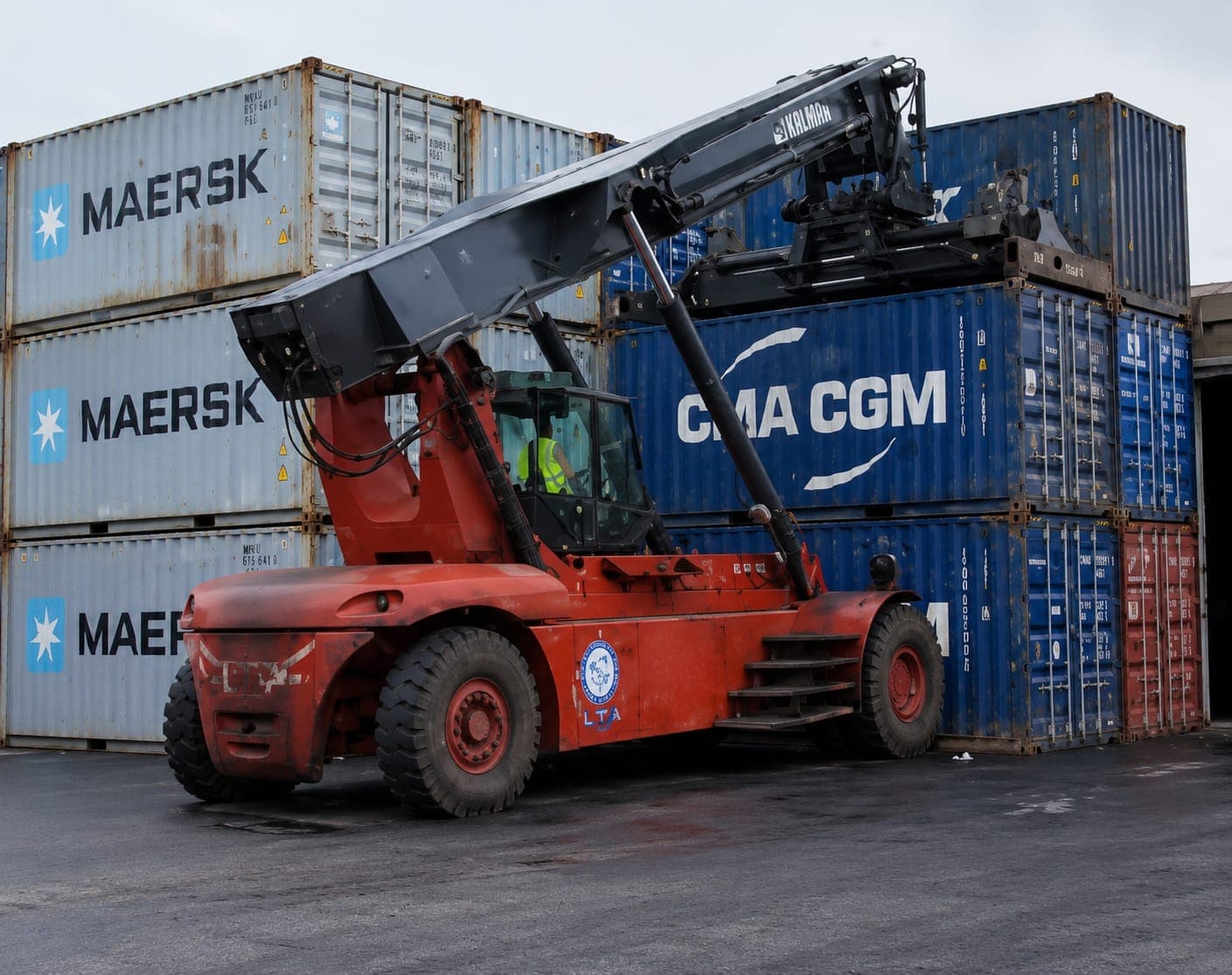 Chariot cavalier LTA saisissant un conteneur maritime