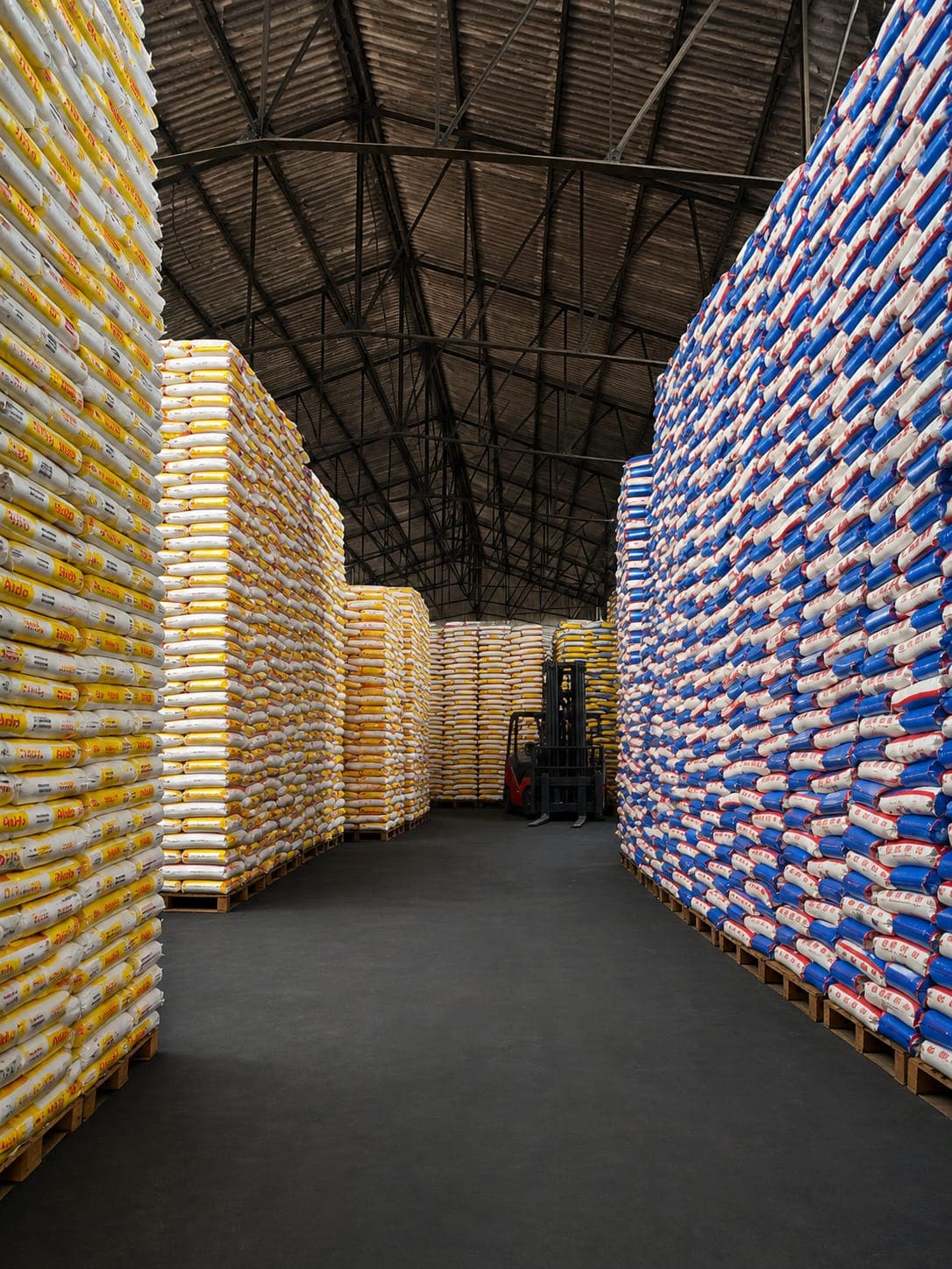 Forklift manoeuvring between two stacks of bagged goods